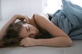 Stressed young lady lying on bed at home. Unhappy woman suffering from nervous tension, emotional disorders