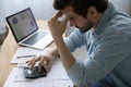 Stressed young man calculating domestic expenses, having financial problems. Royalty Free Stock Photo