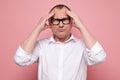 Stressed young man in eyeglasses regretting about something, looking at camera Royalty Free Stock Photo