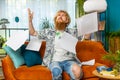 Stressed young man looking at unpaid bank debt loan, doing paperwork, planning budget, throws bills Royalty Free Stock Photo