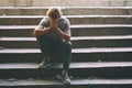 Stressed young man sitting on stairs outdoors Royalty Free Stock Photo