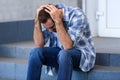 Stressed young man sitting on stairs outdoors Royalty Free Stock Photo