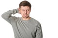 Stressed young man with uncertain puzzled expression, on white background