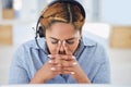 Stressed young mixed race female call centre agent getting a headache while working in office. Consultant making Royalty Free Stock Photo