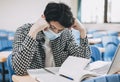 Stressed young  student wearing face mask and studying in  classroom Royalty Free Stock Photo