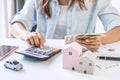 Stressed young woman calculating monthly home expenses and Car installment, Income is not enough for expenses