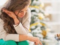 Stressed young woman in front of christmas tree Royalty Free Stock Photo