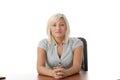 Stressed young woman sitting behind a desk Royalty Free Stock Photo