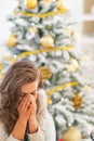 Stressed young woman sitting in front of christmas tree Royalty Free Stock Photo