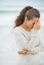 Stressed young woman in sweater on beach with mobile phone Royalty Free Stock Photo