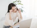 Stressed young woman working on  laptop and talking on the phone in the home office Royalty Free Stock Photo