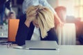 Feeling tired and stressed. Frustrated adult woman keeping eyes closed from fatigue while sitting in office.