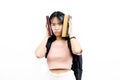 Stressful and upset Asian female college students holding pile of books with bag isolated over white background.