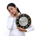 Stressful young business woman holding clock