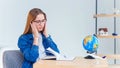 Young female office worker has headache after hard working day. Fatigue and overworked girl keeps hands on temples. Royalty Free Stock Photo