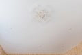 stretch ceiling in white. A decorative chandelier hangs in the center Royalty Free Stock Photo