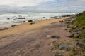 Stretch of Wet Beach and Rocks with Ebbing Tide