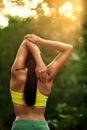 Stretch your limits. a young woman stretching before her run.