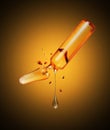 Stretched drop dripping from a crushed medical ampoule in the dark Royalty Free Stock Photo