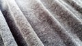 Stretched elastic fabric. Gray material laid in waves. Cloth for sewing covers for chairs, chairs and sofas and for sewing clothes
