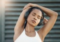 Stretching, city and woman with headphones, fitness or exercise with motivational podcast, relax or stress relief