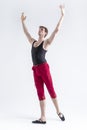 Stretching of Concentrated Contemporary Ballet Dancer Flexible Athletic Man Posing in Red Tights in Ballanced Dance Pose on White