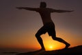 Stretching in the dwindling light. Silhouette of a man doing exercises with the sunset in the background. Royalty Free Stock Photo