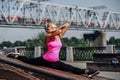 Stretching gymnast woman doing split, twine in urban city background.