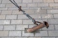 Stretching of metal rope by turnbuckle of ring-hook type attached to ear of rusty pipe embedded in ground and rusted cable clips