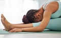 Stretching my hamstrings. an unrecognisable woman practising yoga alone and holding a seated forward fold pose.