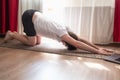 Stretching spine asana. Young caucasian man practicing yoga at home