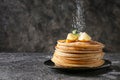 Strewing of tasty thin pancakes with sugar powder