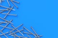 Strewn metal nails on blue background. Building equipment. Tool for repair, renovation. Top view. Copy space