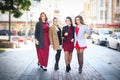 StrFour beautiful fashionable girlfriends walk in sunny weather in the city Royalty Free Stock Photo