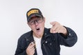 A strict and angry male security guard in his 40s berating someone. Pointing straight at camera. Isolated on a white background