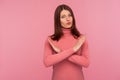 Strict bossy woman with brown hair in pink sweater showing x sign with hands, there is no way more, hopelessness Royalty Free Stock Photo