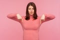 Strict bossy woman in pink sweater indicating fingers down commanding to act here and now, motivation