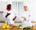 Strict chef reprimanding young female colleague while working in private kitchen