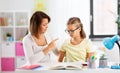 Strict mother talking to daughter doing homework