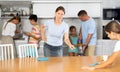 Strict mother tells her daughter how to properly dust off table