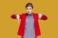 Strict serious woman with red lips pointing both index fingers down, saying here and right now. Royalty Free Stock Photo