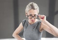 Strict teacher looking through glasses with serious expression