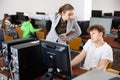 Strict teacher reprimanding negligent teenage student in computer class Royalty Free Stock Photo