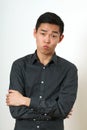 Strict young Asian man with crossed hands looking at camera