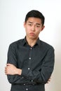 Strict young Asian man with crossed hands looking at camera