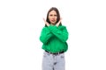 strict young brown-haired female model with brown eyes in a green shirt crossed her arms Royalty Free Stock Photo