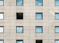 Strictly geometric rectangular exterior view of the facade of a skyscraper with windows and natural stone cladding