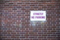 Strictly no parking sign on brick wall background Royalty Free Stock Photo