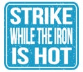 STRIKE WHILE THE IRON IS HOT, words on blue stamp sign Royalty Free Stock Photo