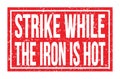 STRIKE WHILE THE IRON IS HOT, words on red rectangle stamp sign Royalty Free Stock Photo